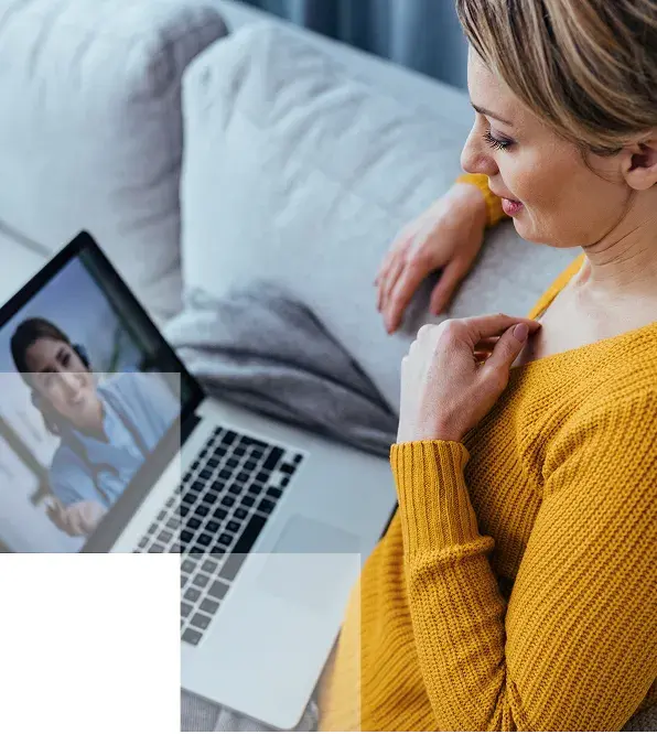 image of a woman in a yellow sweater sitting on the courch on a telehealth call with her laptop on her lap